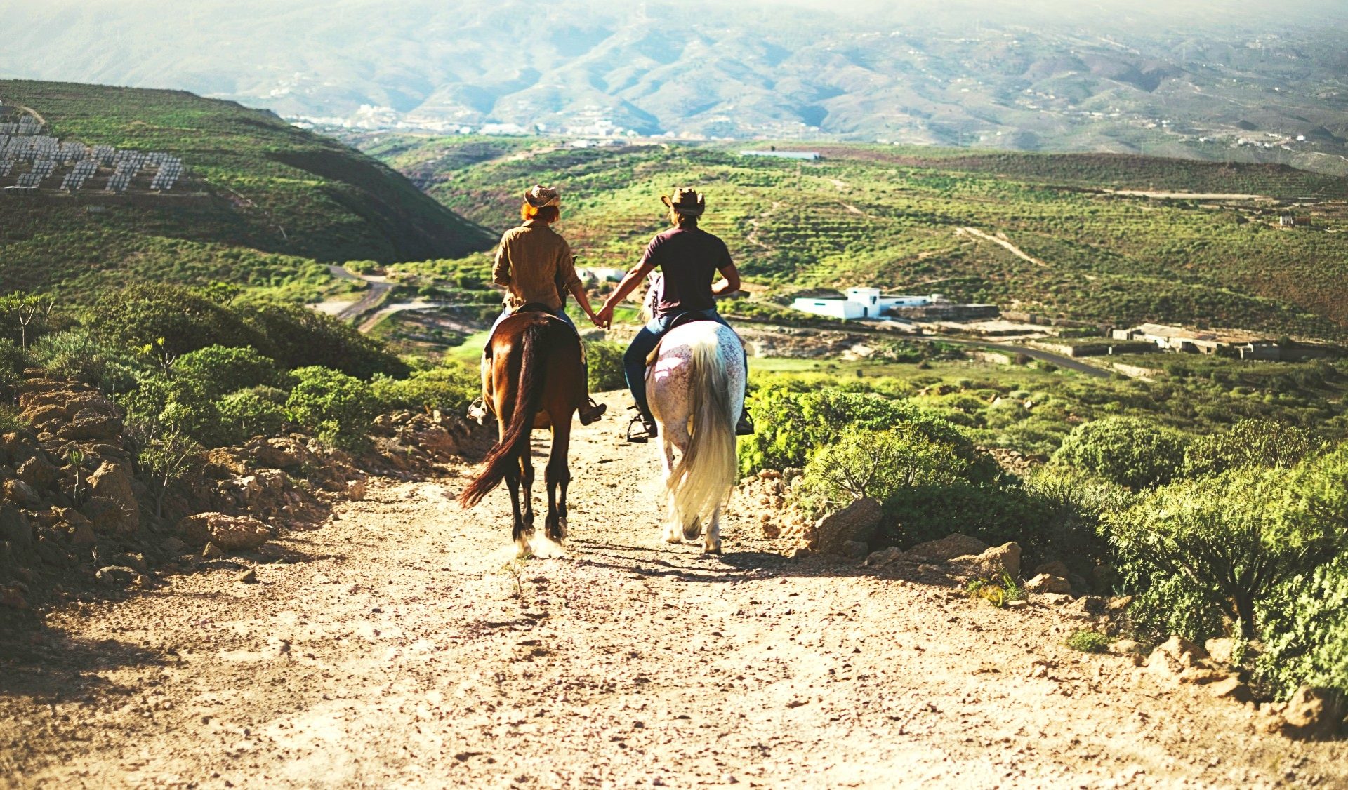 due persone a cavallo su un sentiero sterrato