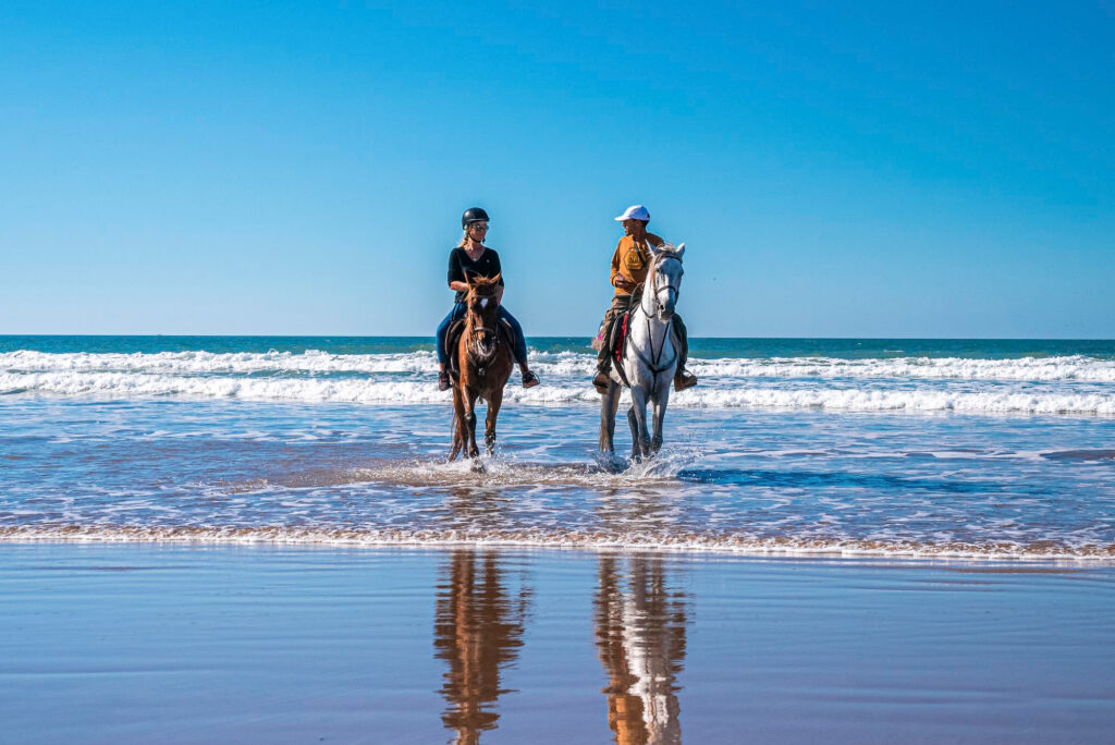 uomo e donna a cavallo in spiaggia