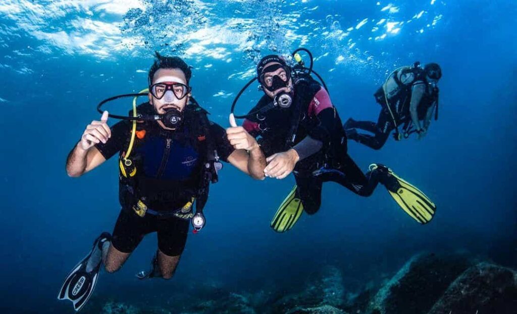 tre ragazzi durante immersione subacquea