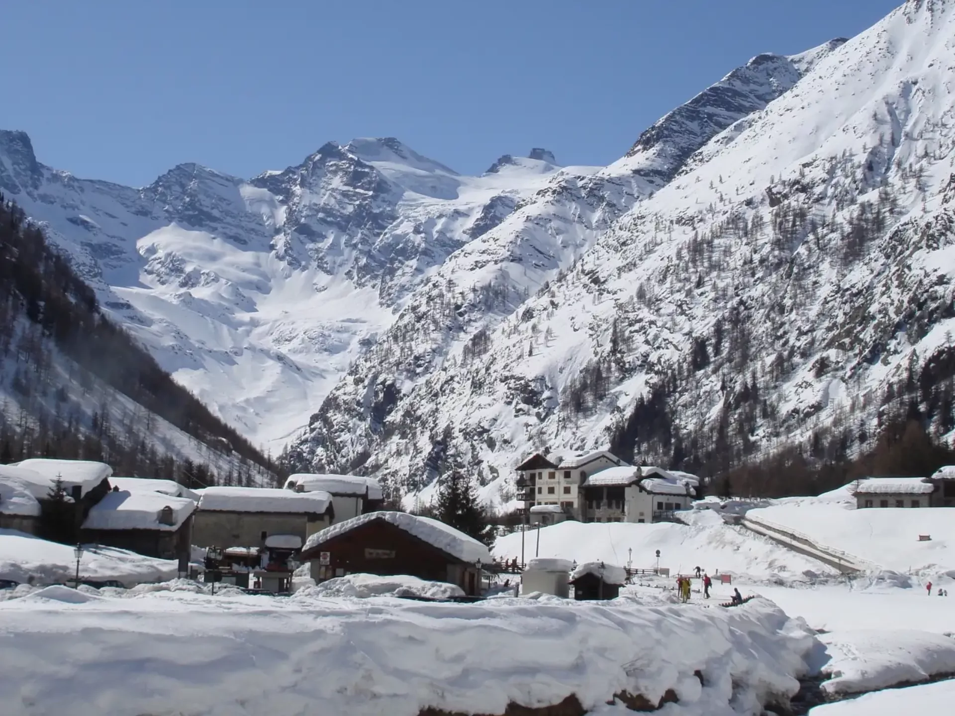 Borgo alpino innevato circondato dalle montagne, ideale per esperienze in Valle d’Aosta tra sci, ciaspolate e vacanze invernali