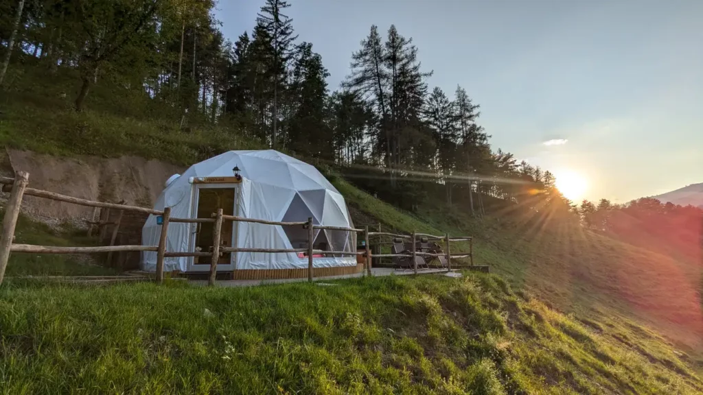 Bubble room in Lombardia su collina al tramonto, cupola geodetica con terrazza e vista sul bosco