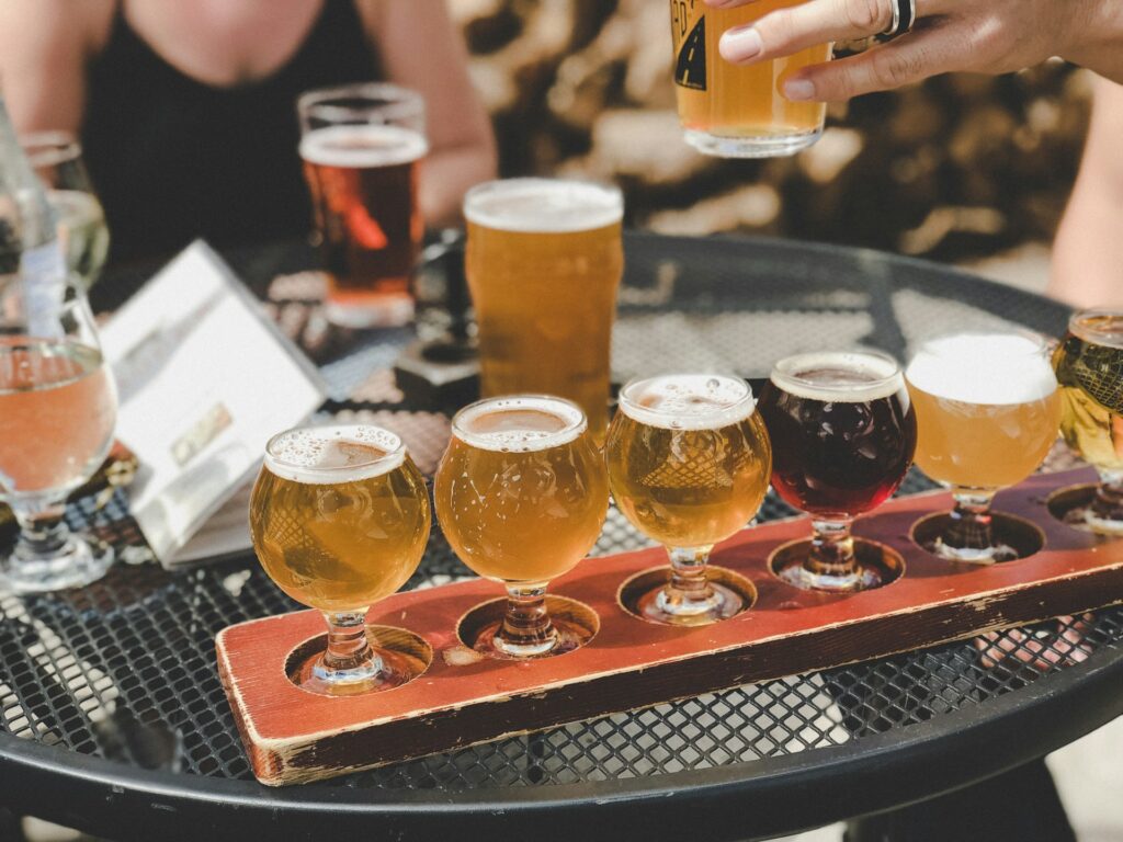 Degustazione di birra artigianale con flight di assaggi in piccoli bicchieri e pinte al tavolo, per scoprire aromi e stili diversi