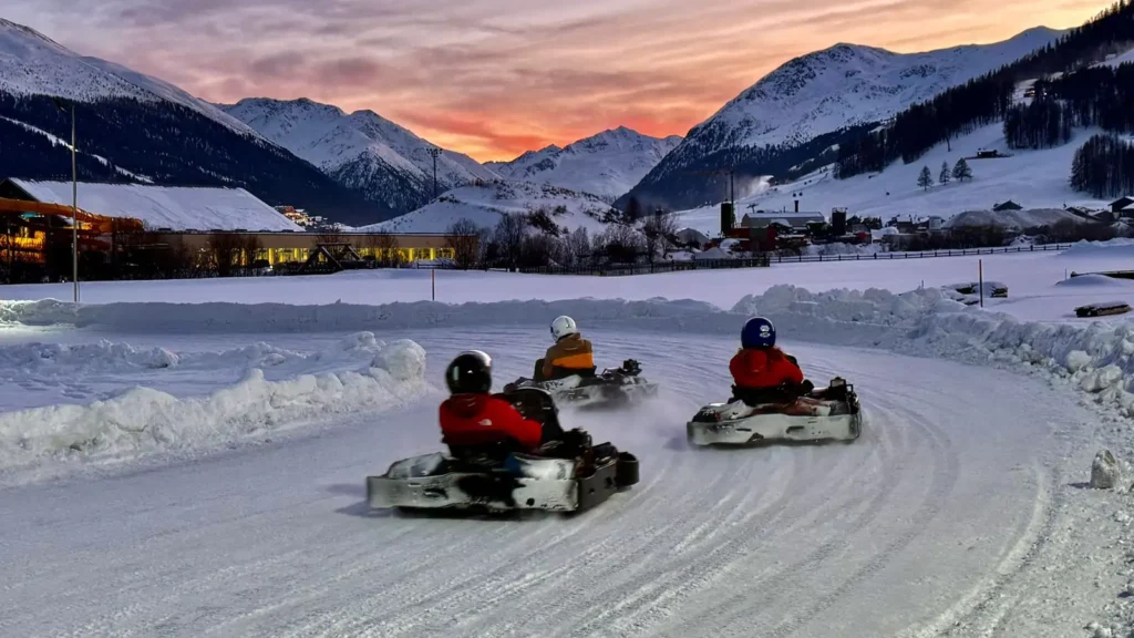 Ice-kart a Livigno al tramonto, gara su pista di ghiaccio con montagne innevate sullo sfondo