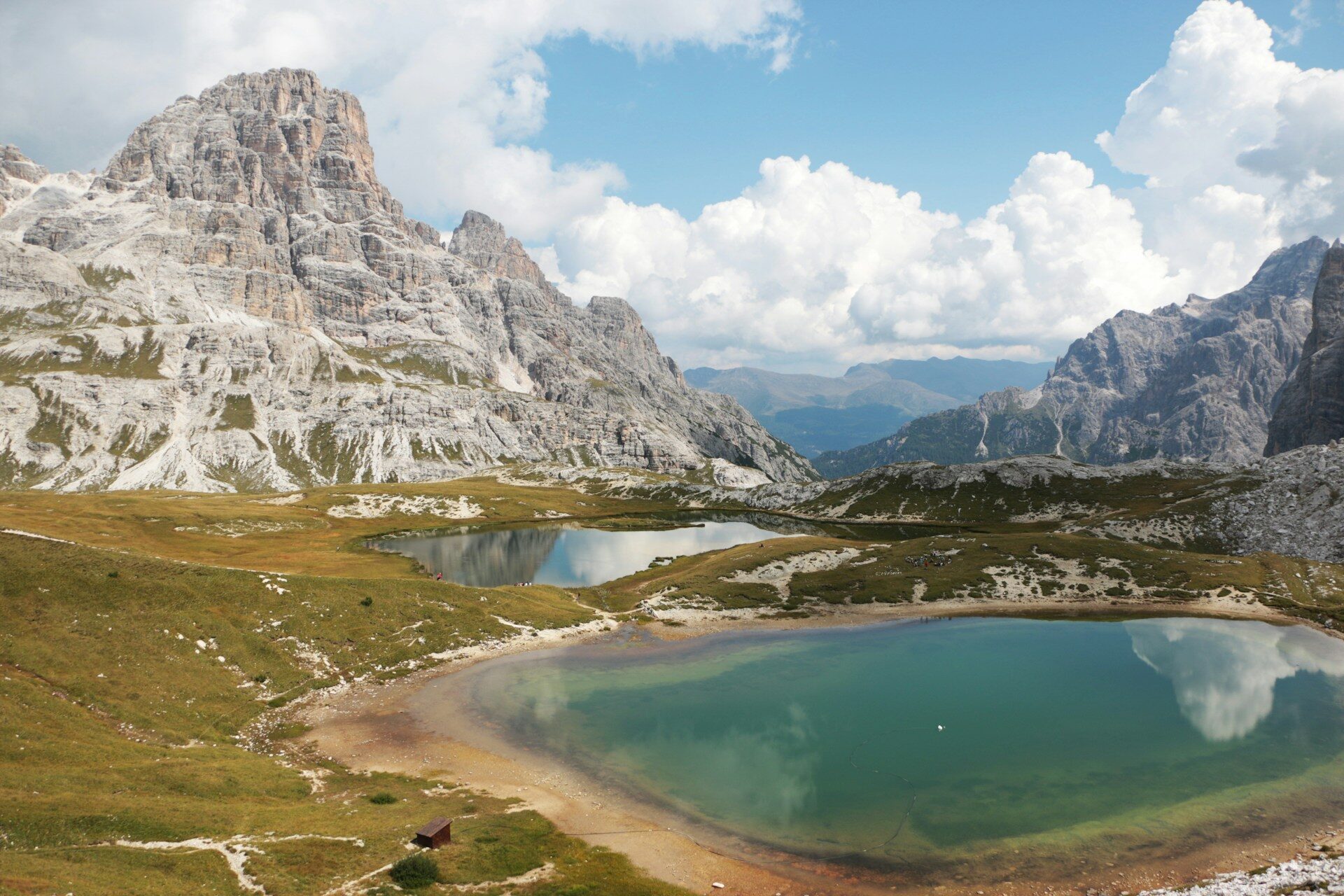 Trekking nelle Dolomiti venete, laghi alpini turchesi tra prati d’alta quota e pareti rocciose