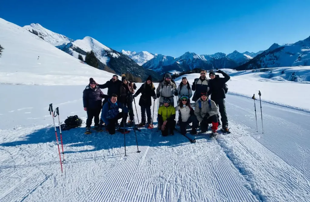 Gruppo durante una ciaspolata in Val Brembana, paesaggio innevato e cime delle Alpi Orobie sullo sfondo