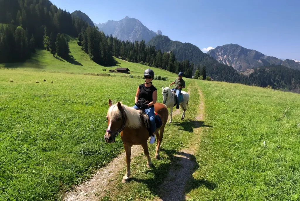 Passeggiata a cavallo in Val Visdende, escursione estiva su sentiero tra prati verdi e montagne