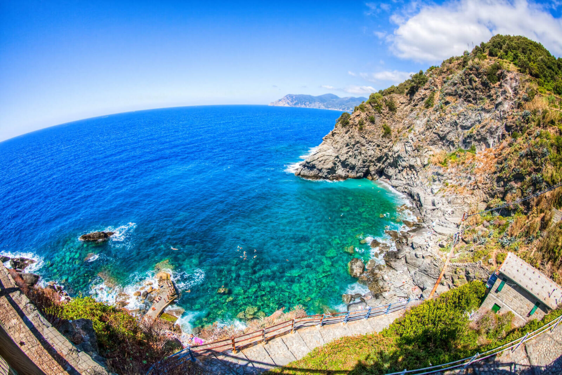 Caletta rocciosa con mare cristallino e sentiero panoramico lungo la costa delle Cinque Terre