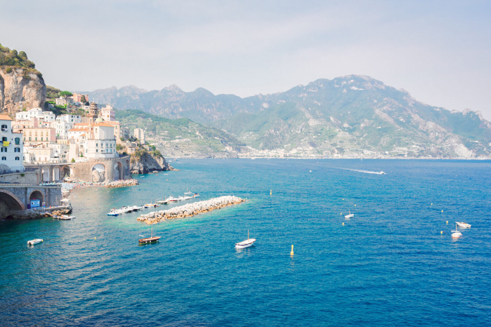 Costiera Amalfitana vista dal mare con barche e il borgo di Atrani, meta ideale per esperienze in Campania