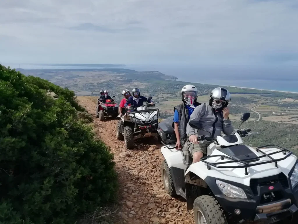 Escursione in quad a Iglesias: gruppo di partecipanti su sentiero sterrato con vista panoramica sulla costa del Sulcis-Iglesiente