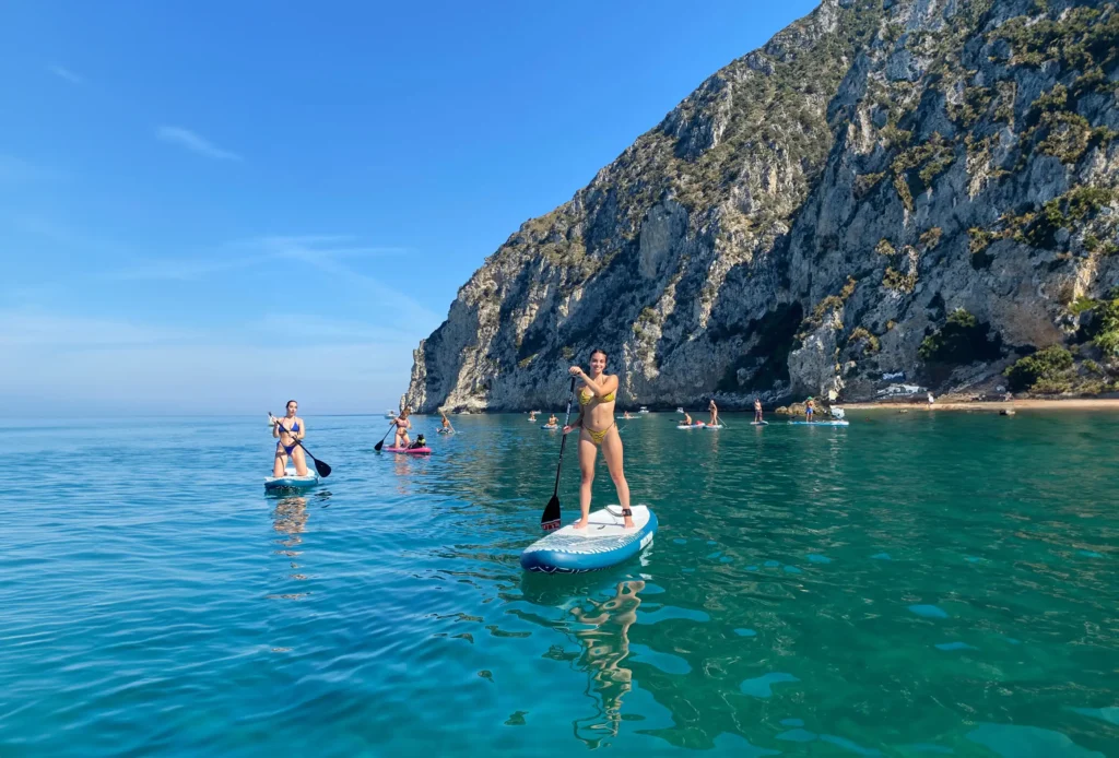 Lezione di SUP stand up paddle nelle acque del Circeo con vista sulla falesia e sulle spiagge nascoste