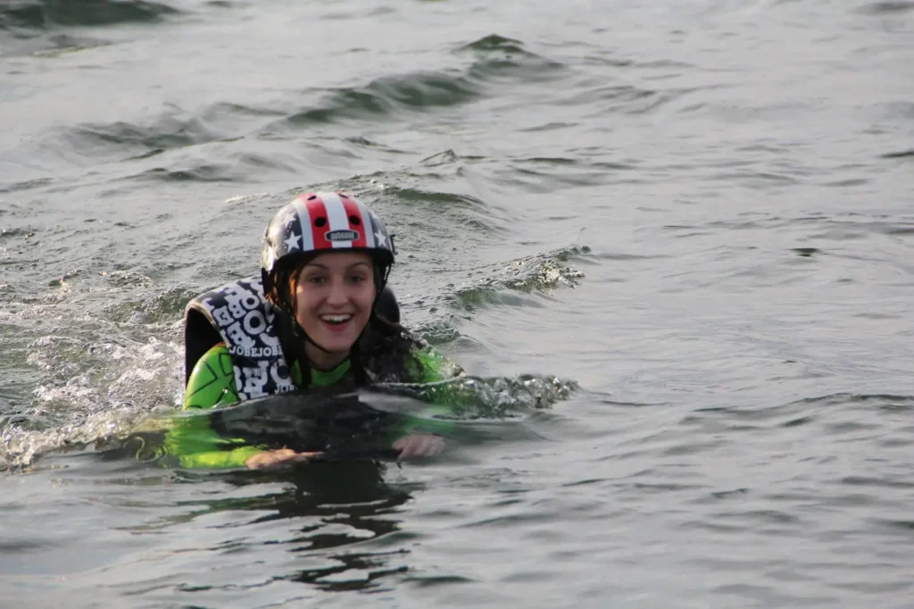 Ragazza con casco e giubbotto durante una lezione di eFoil sul Lago Maggiore a Ispra