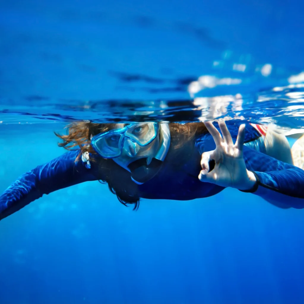 Ragazza in snorkeling sott'acqua con maschera in mare cristallino, snorkeling in Sardegn