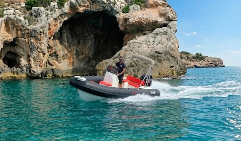 Gommone a noleggio in navigazione lungo le falesie della costa di Alghero
