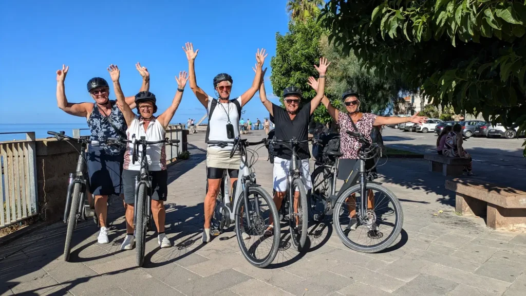 ciclisti in e-bike sul lungomare di porto conte