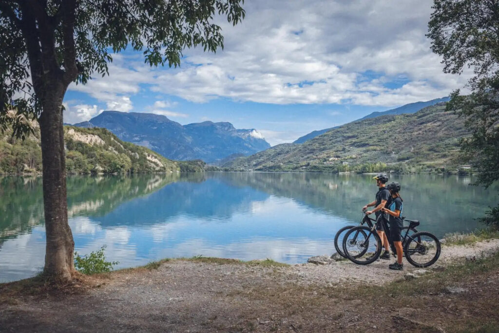 ciclisti in e-bike davanti al lago di ledro
