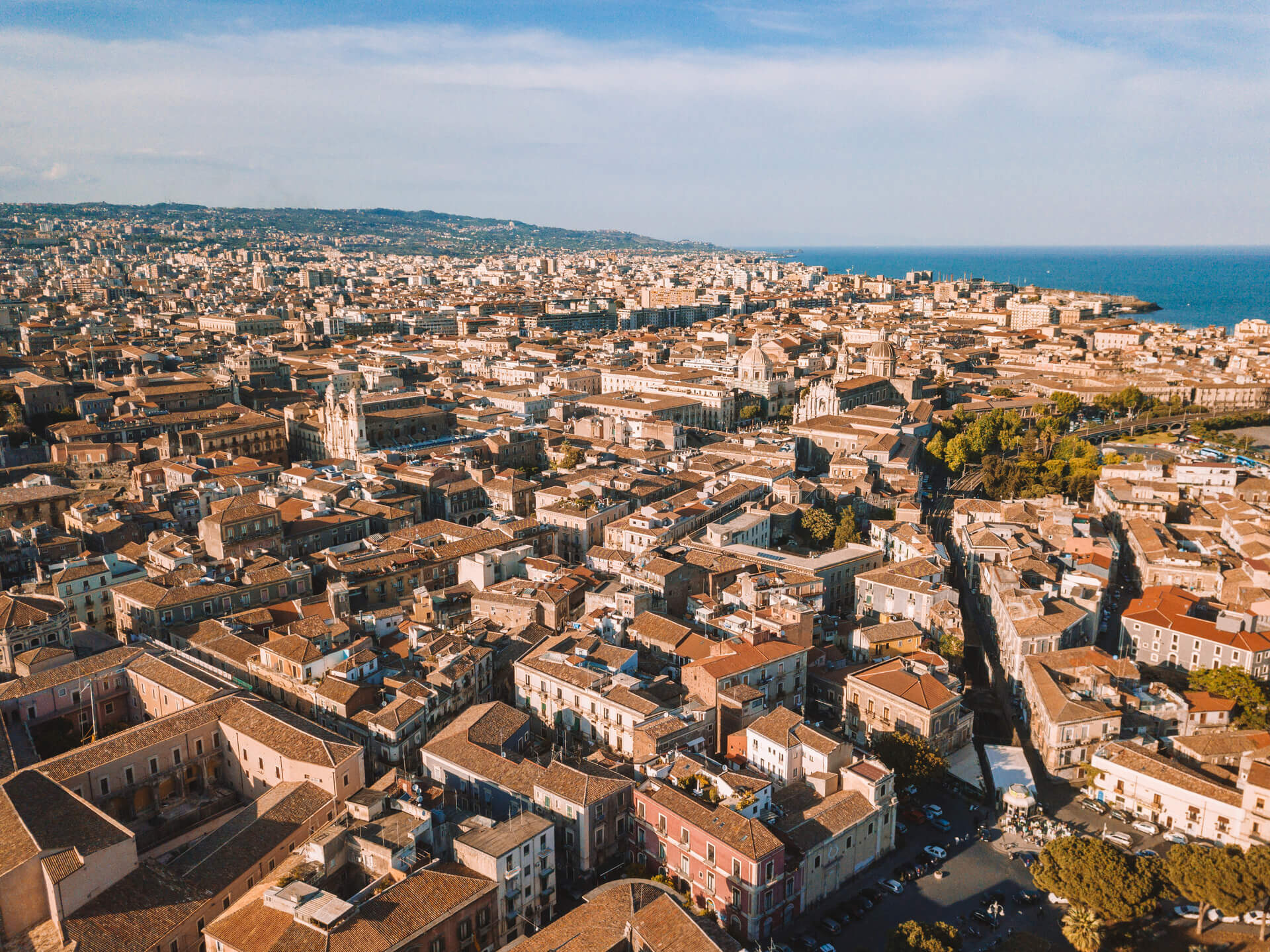 Tetti e cupole del centro storico di Catania visti dall'alto con il mare sullo sfondo